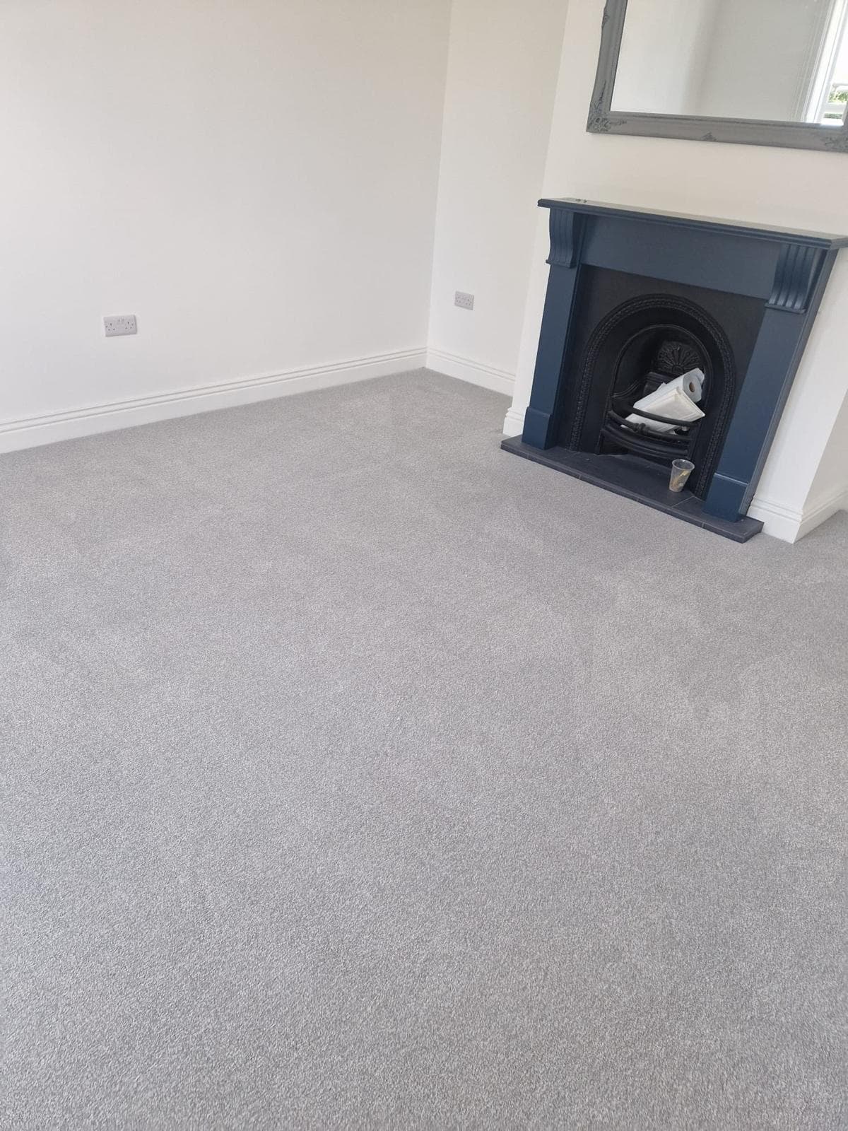 Living room carpet installation with fireplace